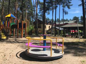 een speeltuin met speeltoestellen in een park bij Hotel Eljot in Sielpia Wielka