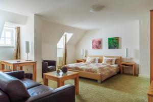 比特堡的住宿－Zum Simonbräu，一间卧室配有一张床、一张沙发和一张桌子