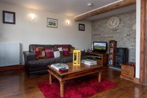a living room with a couch and a coffee table at The Coach House in Penmachno