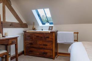 a bedroom with a bathroom with a sink and a window at The Coach House in Penmachno