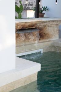 a waterfall over a pool of water in a house at Suite Guagnano Luxury apartment in Nardò