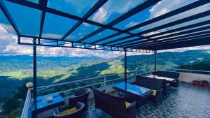 a balcony with a table and chairs and a view at Himalayan Sunrise in Dhulikhel