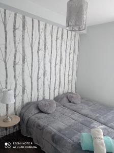 1 dormitorio con 1 cama con árboles en la pared en Zapaterías, en León