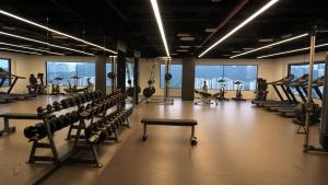 a gym with rows of exercise equipment and windows at G Hotel Kelawai in George Town