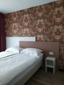 1 dormitorio con cama grande y pared con papel pintado en New Garden, en Nago-Torbole