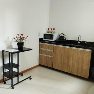 a kitchen with a sink and a microwave at Flat Santa Cruz II in Santa Cruz do Sul