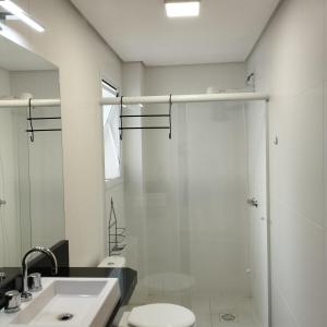 een badkamer met een douche, een toilet en een wastafel bij Flat Santa Cruz II in Santa Cruz do Sul