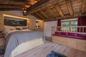 Un dormitorio con una cama grande y un banco púrpura en Piccola Fiamma by Pizzo Fiamma en Zermatt