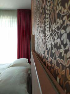 1 dormitorio con 2 camas y una pared con flores en New Garden, en Nago-Torbole
