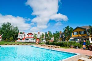 een zwembad in een tuin met huizen bij 146 Borealis - Close to the Mountains in Mont-Tremblant in Mont-Tremblant