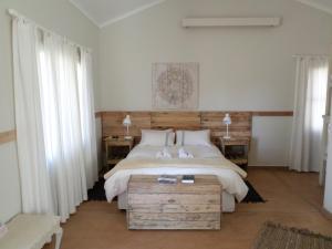 um quarto com uma cama grande e duas mesas e duas janelas em Out Of Nature Country Lodge em Windhoek