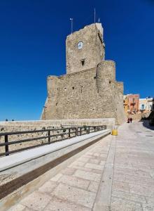 un gran edificio de piedra con una torre de reloj en WANDERLUST HOME, en Termoli