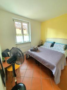 - une chambre avec un lit, une chaise et un ventilateur dans l'établissement Nelson Apartment, à Limone sul Garda