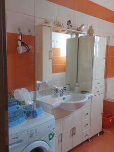 a bathroom with a sink and a mirror and a washing machine at Ulmus Suite in Volos +31 photos