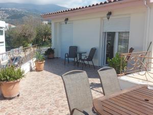 a patio with a table and chairs on a balcony at Ulmus Suite in Volos
