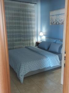 a bedroom with a large bed with blue walls at Ulmus Suite in Volos