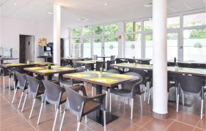 um restaurante com mesas, cadeiras e janelas em Awesome Apartment In quemauville With Kitchen em Équemauville