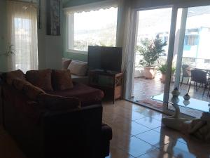 a living room with a couch and a television at Ulmus Suite in Volos