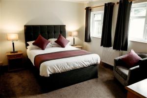 a bedroom with a large bed and a chair at St. Davids Cross Hotel in St. Davids