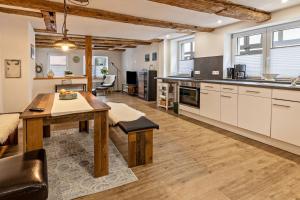 a large kitchen with a wooden table and a dining room at Schmid am See in Gaienhofen