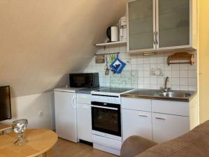 a small kitchen with white appliances and a table at An der Aue 15 Wohnung Ley in Dahme