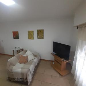 Sala de estar con cama y TV en Sterlizia departamento en Olavarría