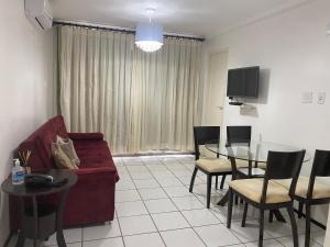 ein Wohnzimmer mit einem roten Sofa und einem Glastisch in der Unterkunft Gran Lençóis Flat Residence in Barreirinhas