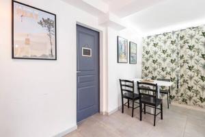 une salle à manger avec une porte bleue, une table et des chaises dans l'établissement CHAMBRE ZEN, à Mérignac