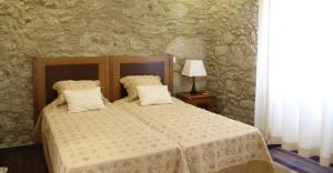a bedroom with a bed and a table with a lamp at Quinta Anna Horvath in Vale de Cambra