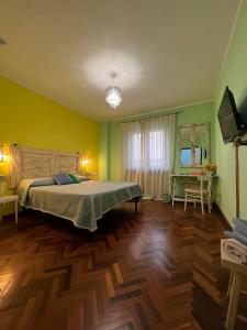 een slaapkamer met een groot bed en een houten vloer bij B&B Casa Caporali in Fabriano
