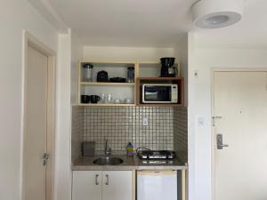 cocina con fregadero y microondas en Gran Lençóis Flat Residence en Barreirinhas