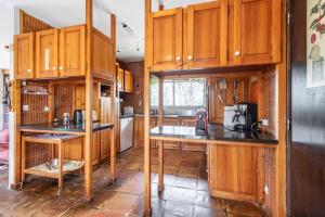 cocina con armarios de madera y encimera en Large contemporary house with indoor swimming pool, en La Gaudaine
