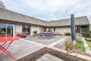 un patio con mesa y sillas y un edificio en Large contemporary house with indoor swimming pool, en La Gaudaine