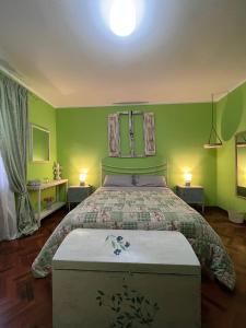 1 dormitorio con 1 cama grande y paredes verdes en B&B Casa Caporali, en Fabriano