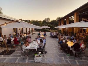 um grupo de pessoas sentadas em mesas fora de um edifício em FORESTERIA DEL GAVI em  Tassarolo