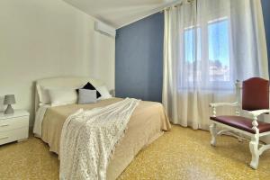 una camera da letto con un letto, una sedia e una finestra di [Incantevole Rifugio al MARE]Wi-Fi parking Clima a Porto San Giorgio