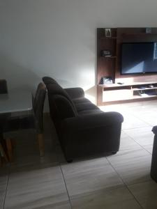 a living room with a black couch and a table at Recanto do Sossego in Alto Caparao