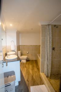 a bathroom with a toilet and a sink and a shower at Stay at The Point - Copper Cove in Durban