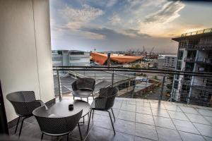 a balcony with chairs and a table and a view of a city at Stay at The Point - Copper Cove in Durban