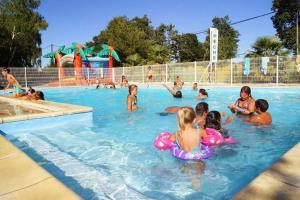 a group of children in a swimming pool at Camping maeva Escapades Les Etangs Mina in Saint-Sornin