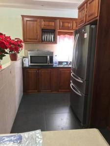 eine Küche mit einem schwarzen Kühlschrank und einer Mikrowelle in der Unterkunft Comfortable home in San Fernando in San Fernando