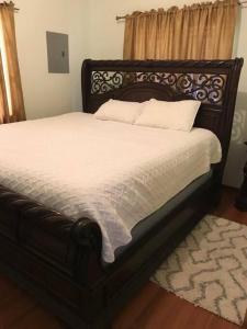 ein Bett mit weißer Bettwäsche und Kissen in einem Schlafzimmer in der Unterkunft Comfortable home in San Fernando in San Fernando