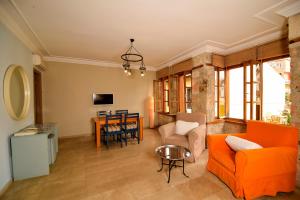 a living room with an orange couch and a table at Gorgeous Flat near Hadrian's Gate in Antalya