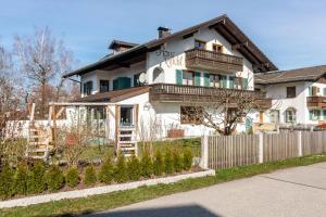una casa blanca con una valla delante en 1 Haus Reichl en Gstadt am Chiemsee