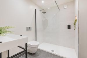 Un baño blanco con ducha y WC. en Laurel a luxury rural retreat, en Staveley