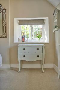 eine weiße Kommode in einem Zimmer mit Fenster in der Unterkunft Boutique Chic In Blockley in Blockley + 34 Fotos