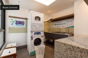 uma lavandaria com máquina de lavar e secar roupa em Charlie Cobogó Pinheiros em São Paulo