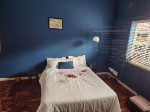 a blue bedroom with a bed with flowers on it at Melvilla House in Johannesburg
