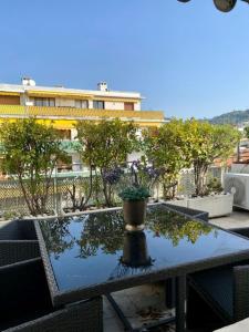 una mesa con una maceta en la parte superior de un balcón en Arthur Properties Rue d'Antibes, en Cannes