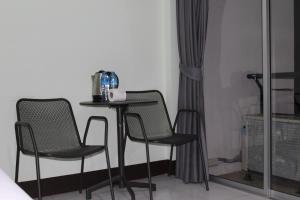 a small table and two chairs in a room at Omaya GuestHouse in Patong Beach